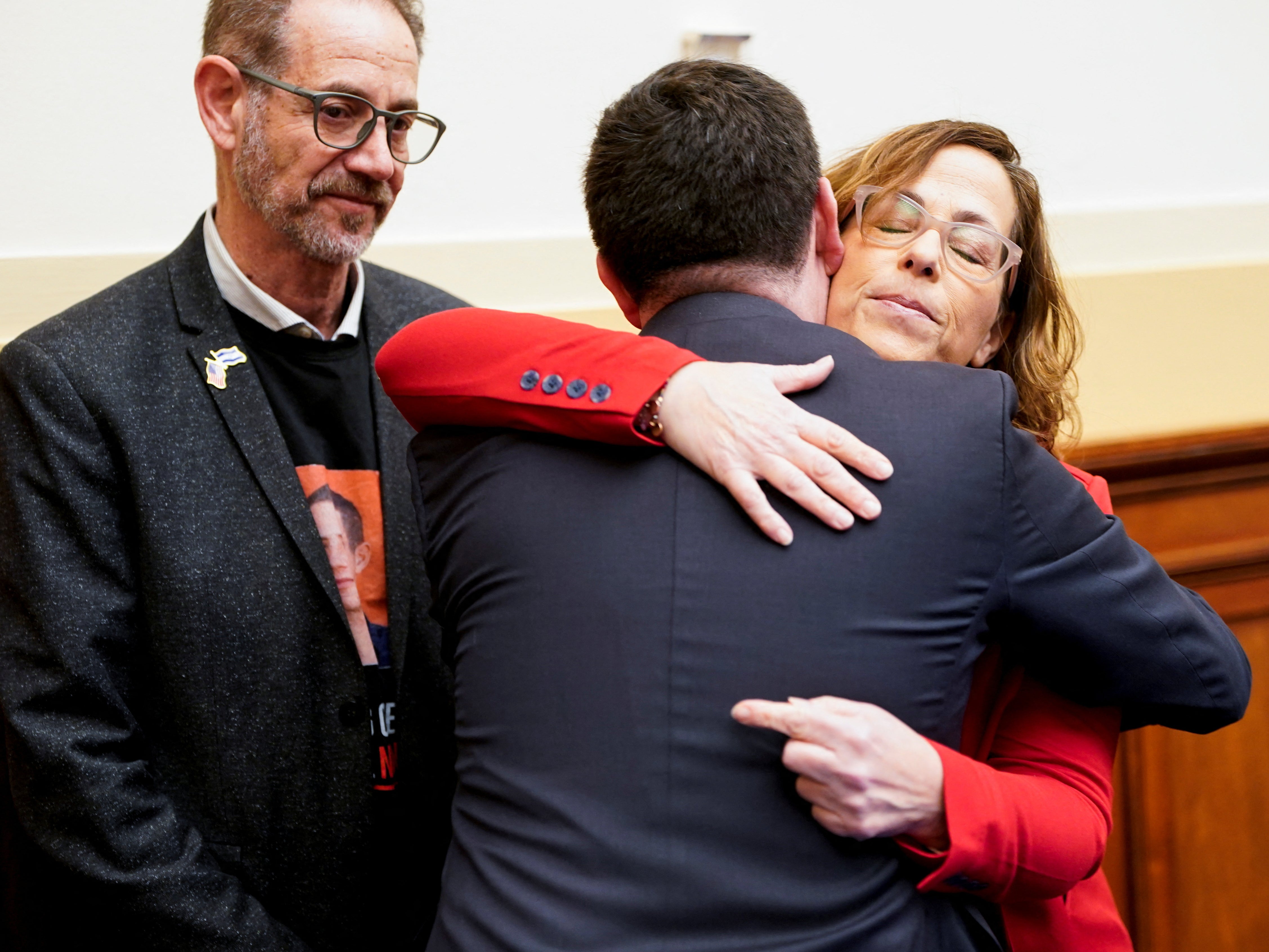 Orna Neutra hugs Rep. Mike Lawler, as Ronen Neutra looks on. Their son Omer Neutra is a hostage