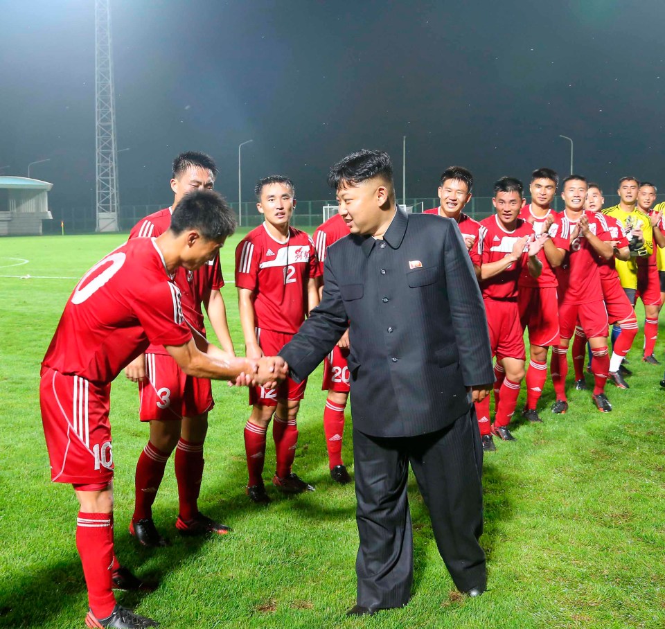 Kim Jong-un shaking hands with soccer players.