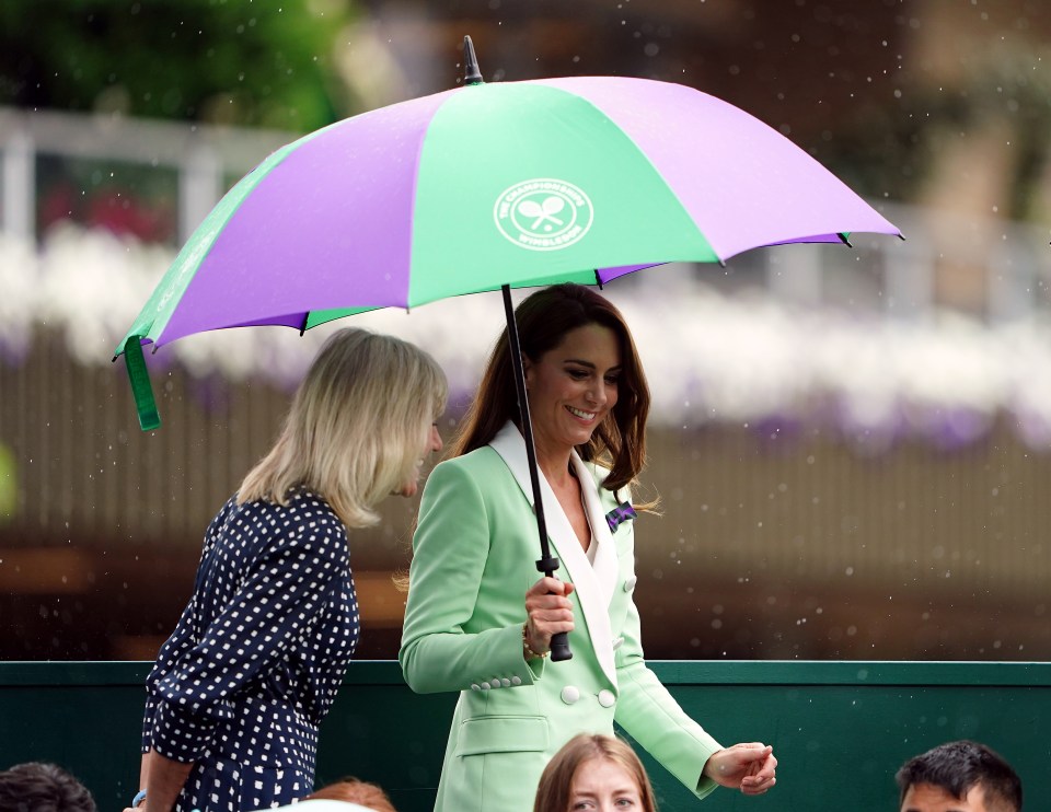 The Princess of Wales and another woman under a Wimbledon umbrella.