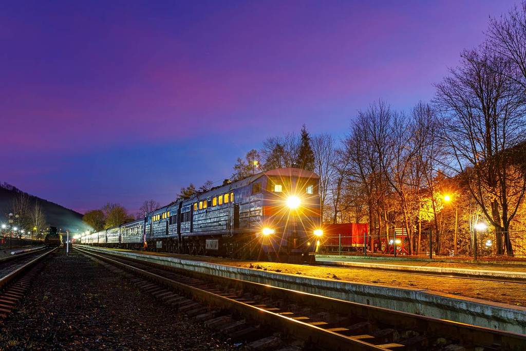 A sleeper train pulled up at a station platform at nightitme