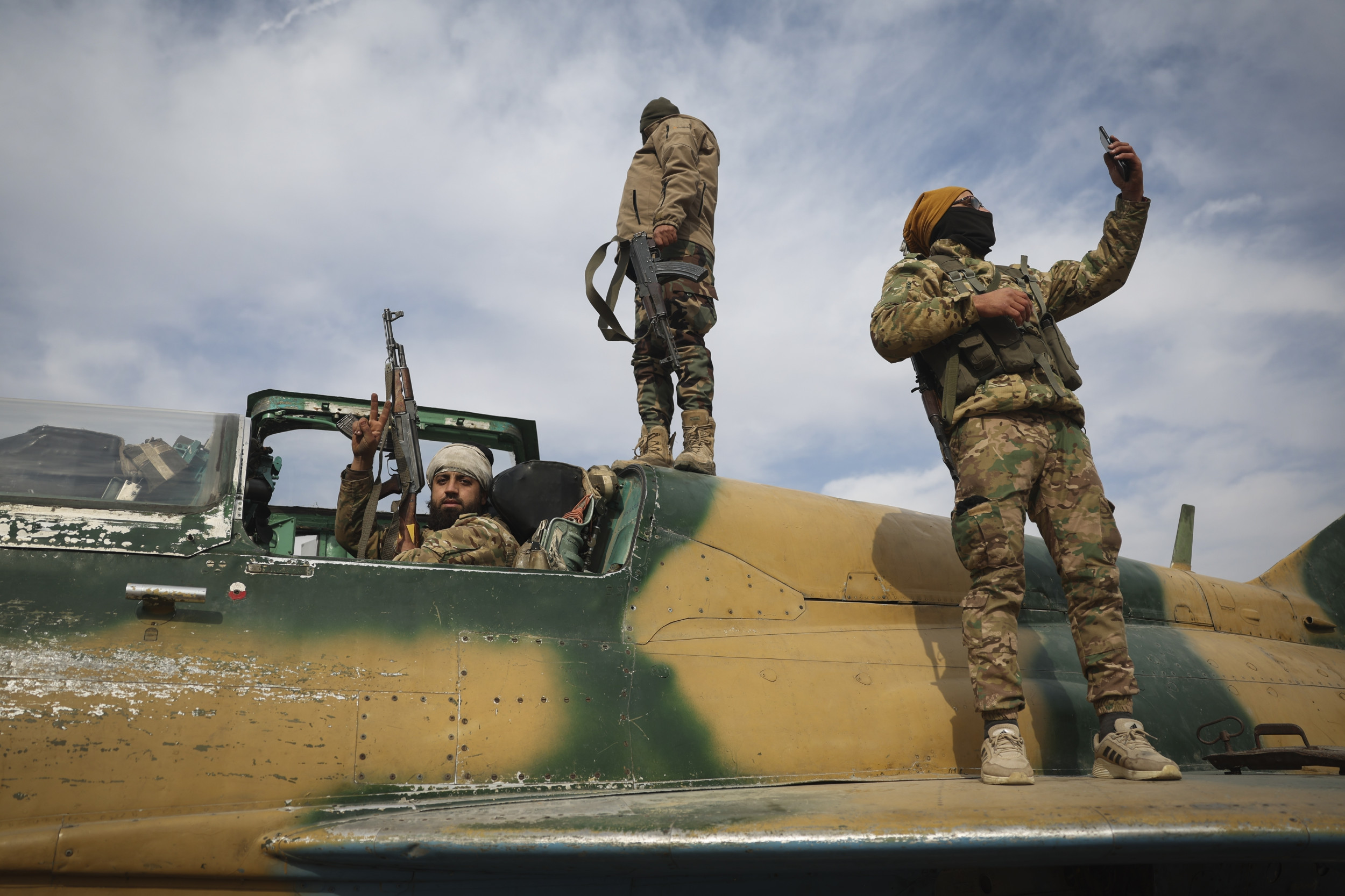 Syrian fighters stand atop seized plane