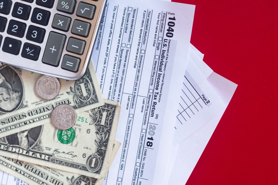 Tax form 1040, calculator, and money.