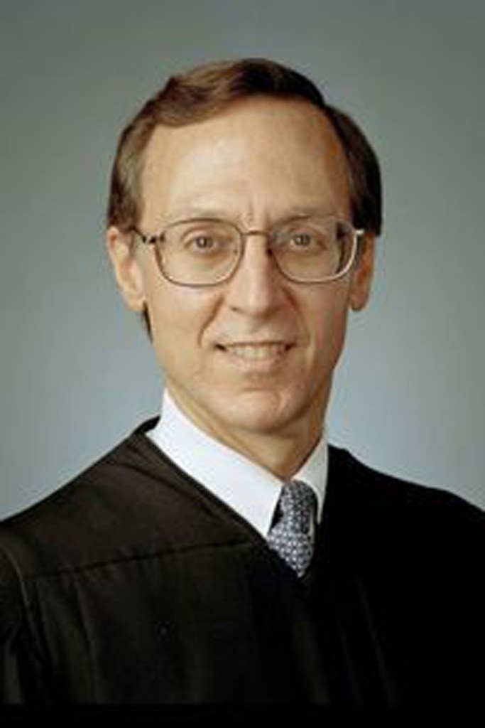 Judge John D. Bates wearing glasses and a black suit