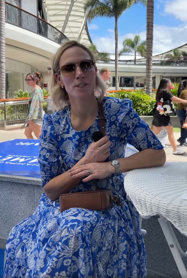 Zara Tindall in a blue floral dress at an outdoor mall.