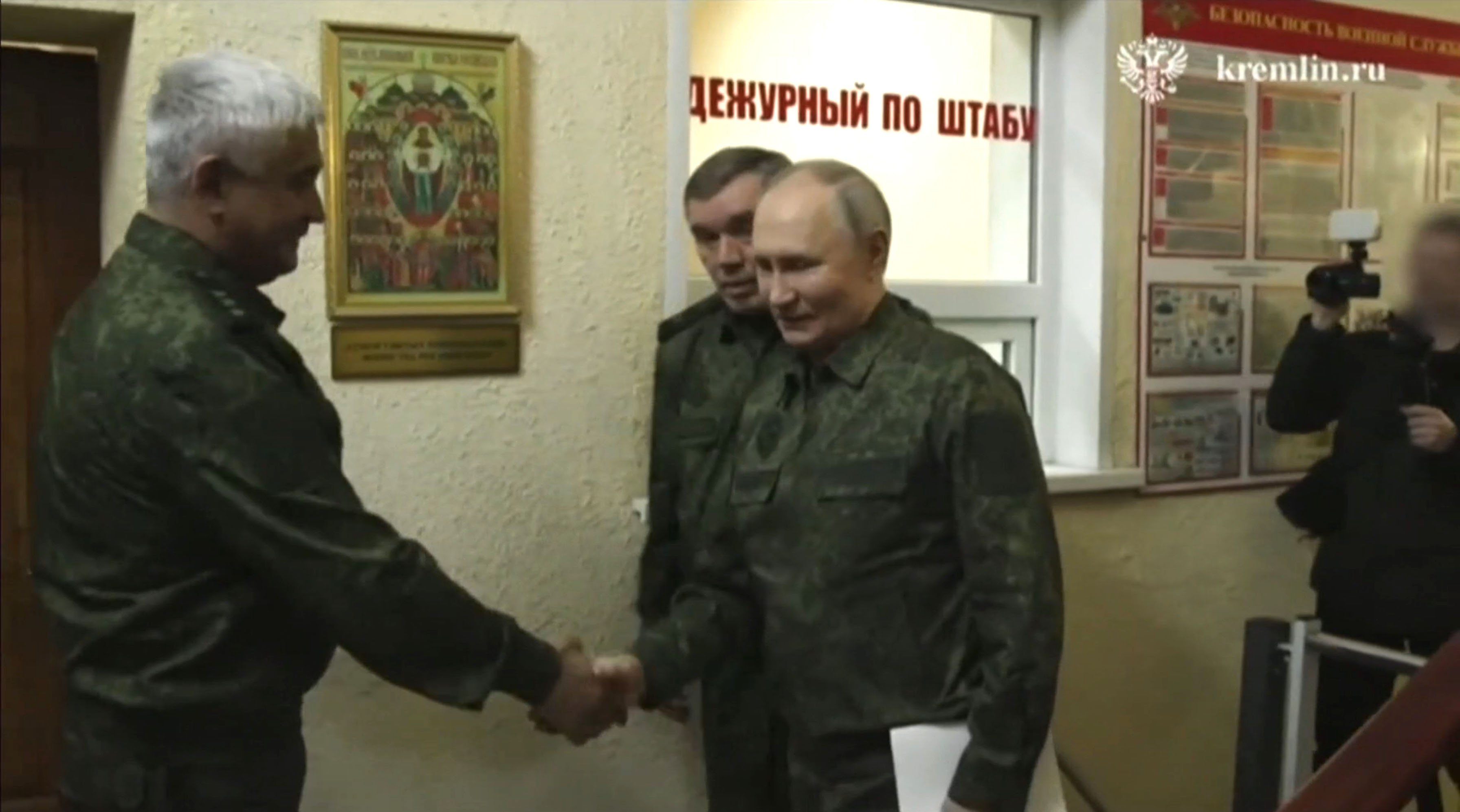 Vladimir Putin shaking hands with a military officer in Kursk.