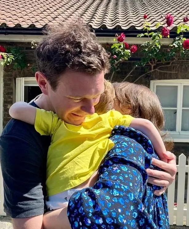Eugenie and Jack cuddle one of their sons 