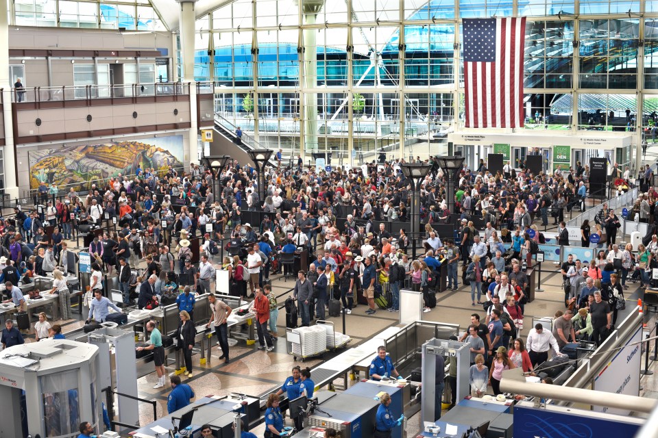 Large crowd of people waiting in line for TSA security at an airport.