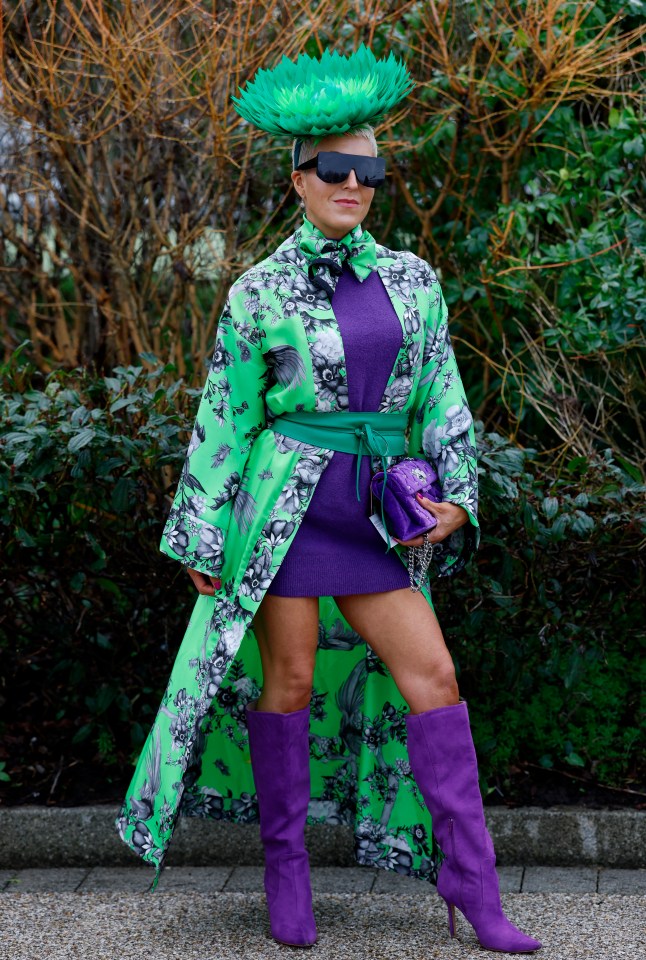 Woman in purple and green outfit at a horse race.
