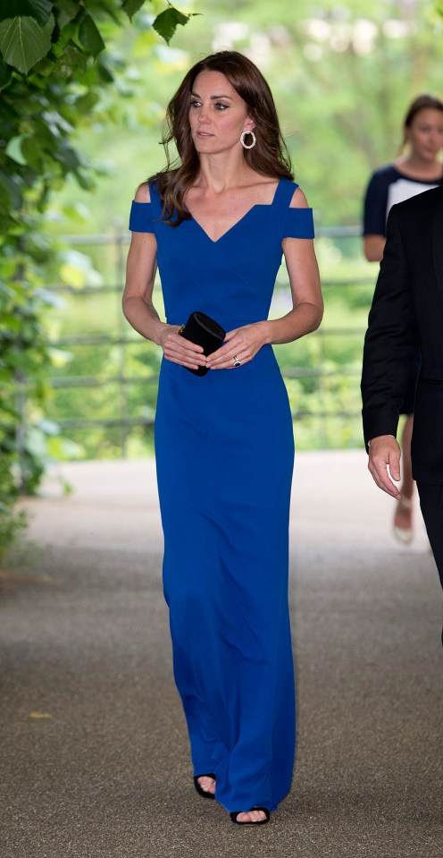 Catherine, Duchess of Cambridge, in a blue dress, arrives at an event.