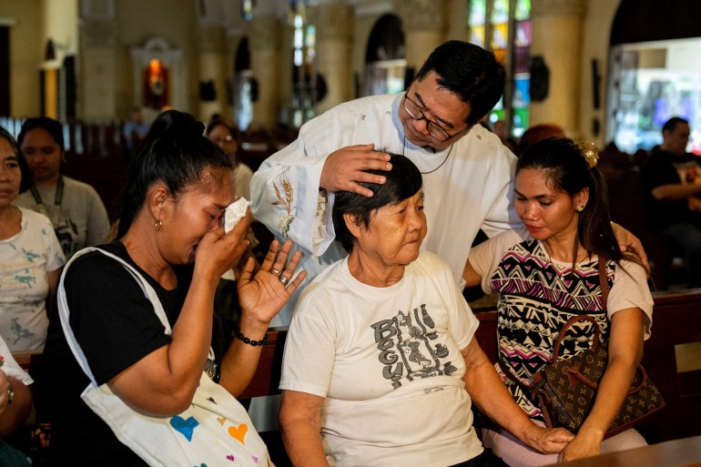 Catholic priest Flavie Villanueva comforts relatives of victims of drug war and extrajudicial killings, before a mass following the arrest of former Philippine President Rodrigo Duterte, in Quezon City, Philippines, March 11, 2025. REUTERS/Lisa Marie David TPX IMAGES OF THE DAY