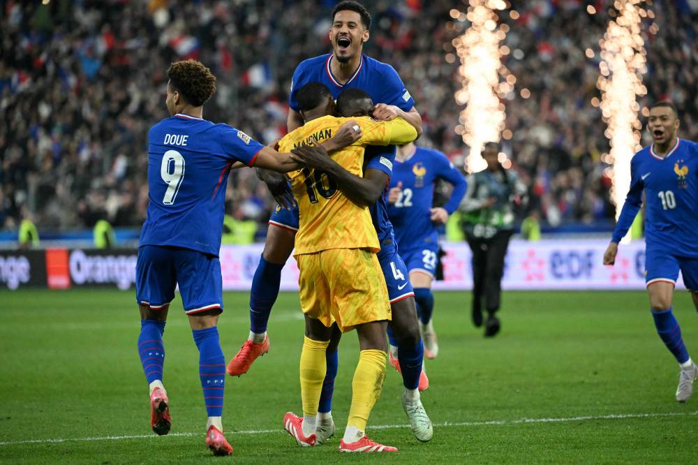 France's players celebrate their victory from a penalty shoot-out at the end of the UEFA Nations League quarter-final second-leg football match between France and Croatia at the Stade de France in Saint-Denis, north of Paris, on March 23, 2025. (Photo by Bertrand GUAY / AFP)