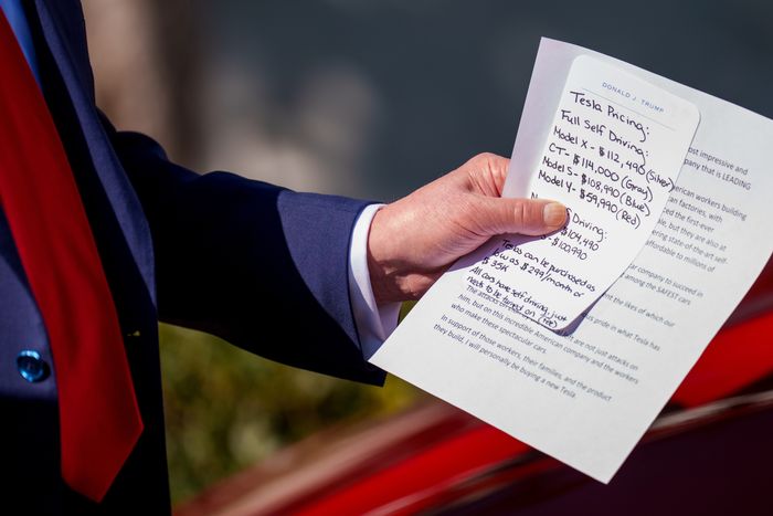President Donald Trump holds notes on the pricing of Tesla vehicles as he delivers remarks on the South Lawn of the White House on March 11