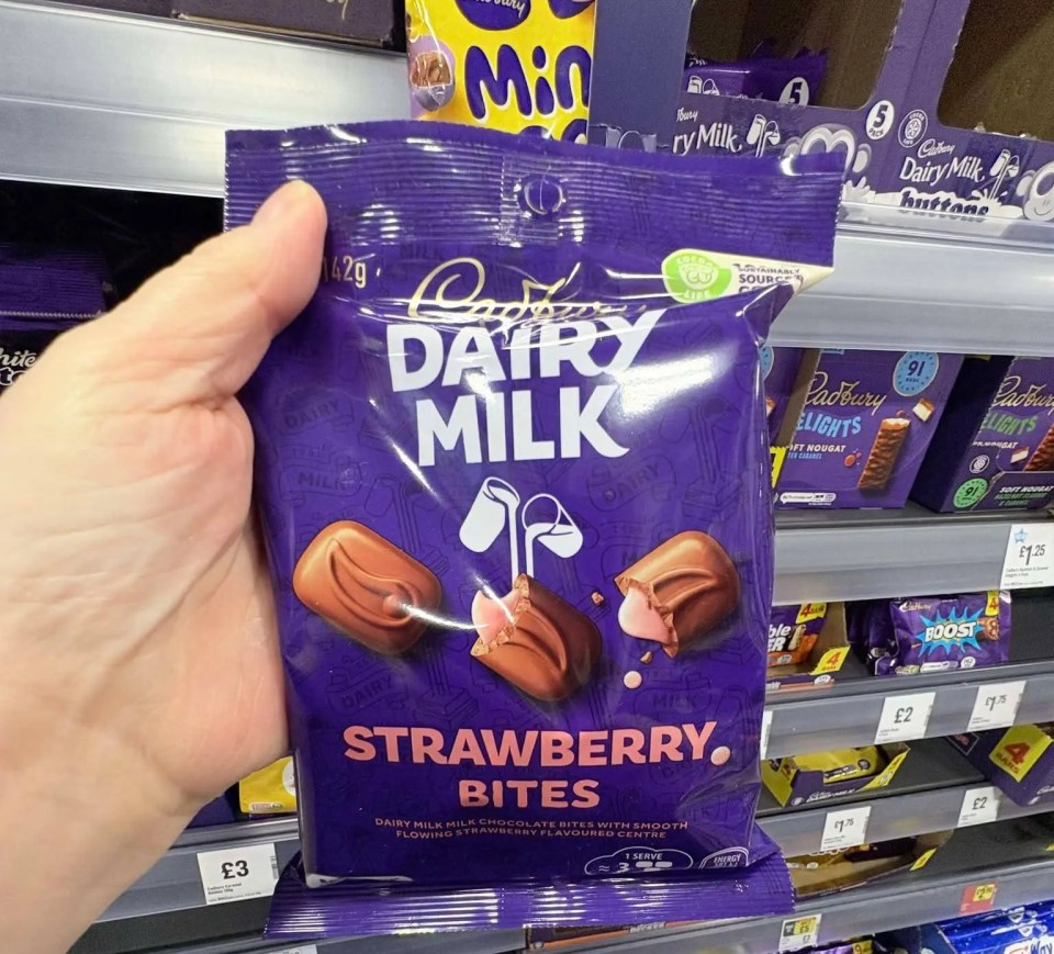 Hand holding a bag of Cadbury Dairy Milk Strawberry Bites.