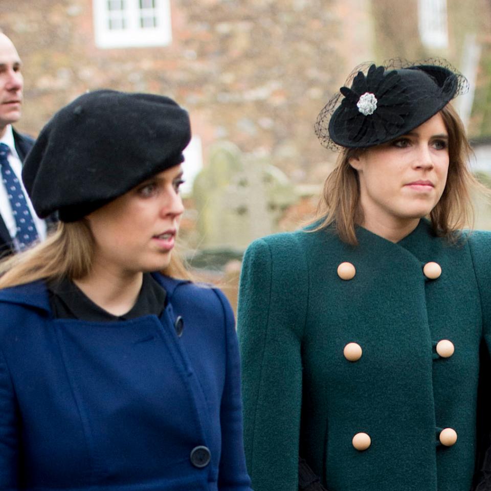 Princess Beatrice wears a blue coat and Princess Eugenie wears a green coat with gold buttons.