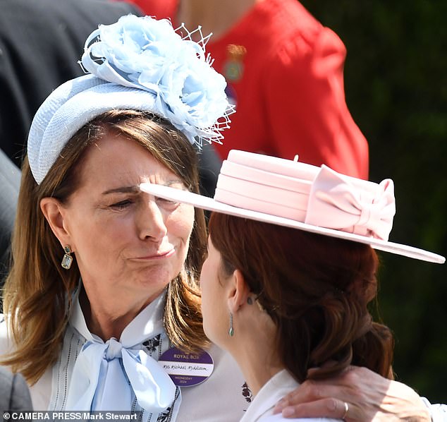 Carole Middleton wrapped her arm affectionately around Eugenie who wore her hair in an up do, revealing her unusual tattoo