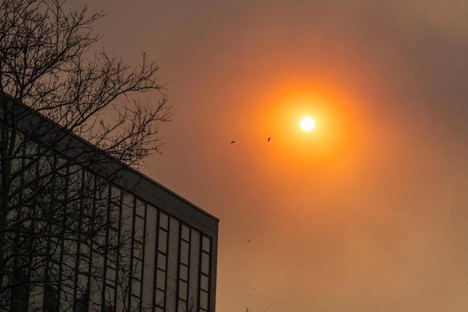 Dust and smoke from wildfires in Oklahoma blown by high winds obscure the sun on Friday, March 14, 2025, in Kansas City.