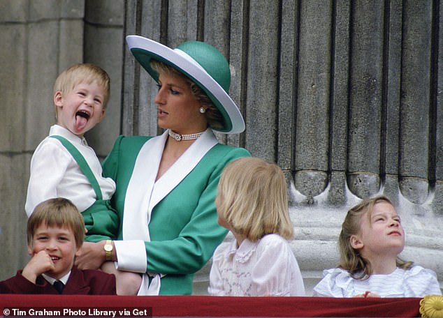 Harry sticks his tongue out while being held by his mother in 1988