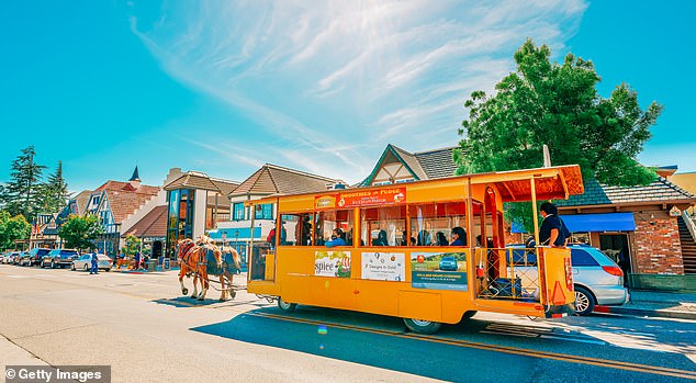 A horse-drawn trolley takes tourists down the street in Solvang