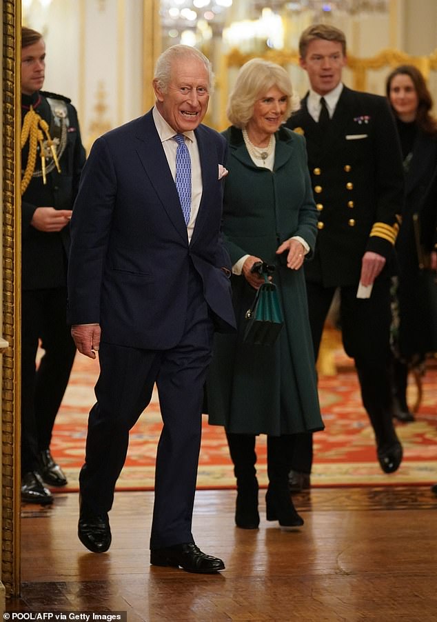 Britain's King Charles and Queen Camilla arrive with equerry Lieutenant Commander Will Thornton (R) and equerry Major Oliver 'Ollie' Plunket (L) to meet members of the The Military Wives Choirs, at Buckingham Palace in London on December 11, 2024