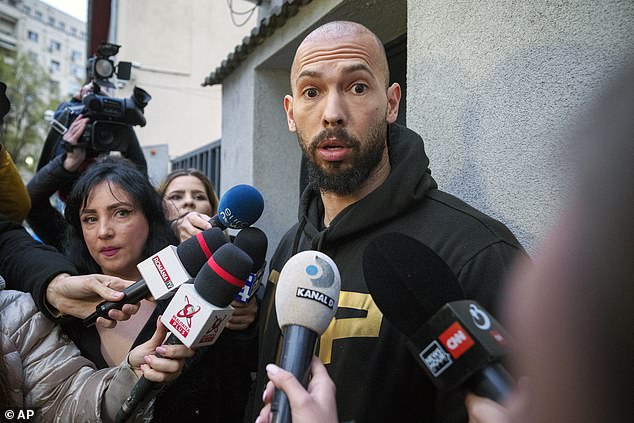 Andrew Tate grimaces upon exiting a police detention facility in Bucharest, in March 2024