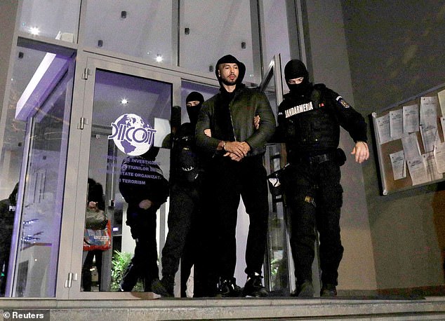 Andrew Tate and Tristan Tate (not pictured) are escorted by police officers outside the headquarters of the Directorate for Investigating Organized Crime and Terrorism in Bucharest in December 2022