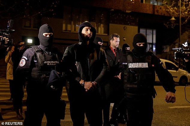 Andrew Tate and Tristan Tate are escorted by police officers in December 2022