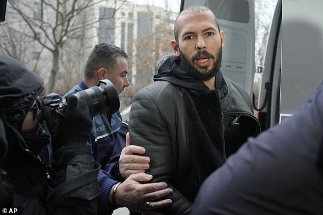Police officers escort Andrew Tate, handcuffed to his brother Tristan, outside the Directorate for Investigating Organized Crime and Terrorism (DIICOT) in Bucharest, January 2023