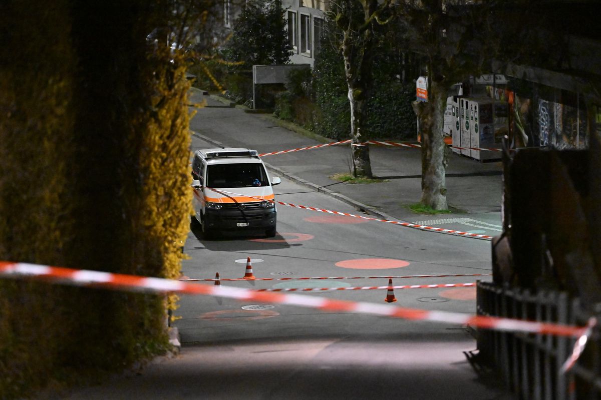Polizeiauto hinter Absperrung in einer Stadtstrasse bei Nacht.