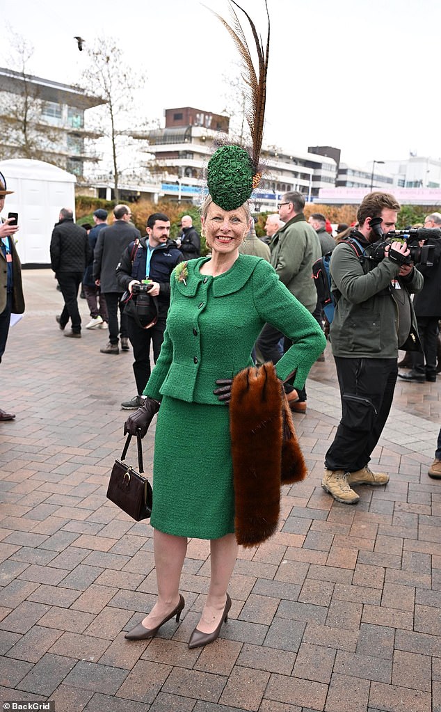 Another attendee shows off her coordinated emerald green look, including a matching hat with a long feather attached to it