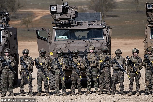 French soldiers stand in line in front of their military vehicles following a combat simulation during the ''Scorpion Days'' manuevers at the French army Canjuers camp, in the Var department, south-eastern France on March 4, 2025