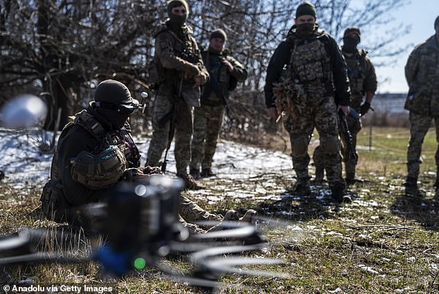 Soldiers from the 42nd Brigade observe as a drone operator controls a BC kamikaze drone during testing before deployment to the frontline in the Kharkiv region, Ukraine yesterday