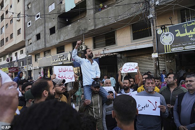Palestinians hold signs and chant slogans against Hamas during anti-war protests in a rare show of public anger against the militant group that rules the territory, in Deir al-Balah Gaza Strip, Wednesday, March 26, 2025