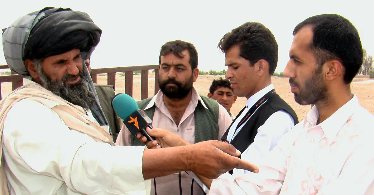 Salih Mohammad Salih, a reporter for Radio Free Europe / Radio Liberty, interviews an Afghan citizen in Helmand Province. (Photo via Wikimedia Commons)