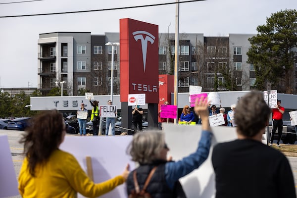 Protestors demonstrate against Elon Musk and President in front of the Tesla dealership in Decatur on Saturday, March 8, 2025. (Arvin Temkar / AJC)