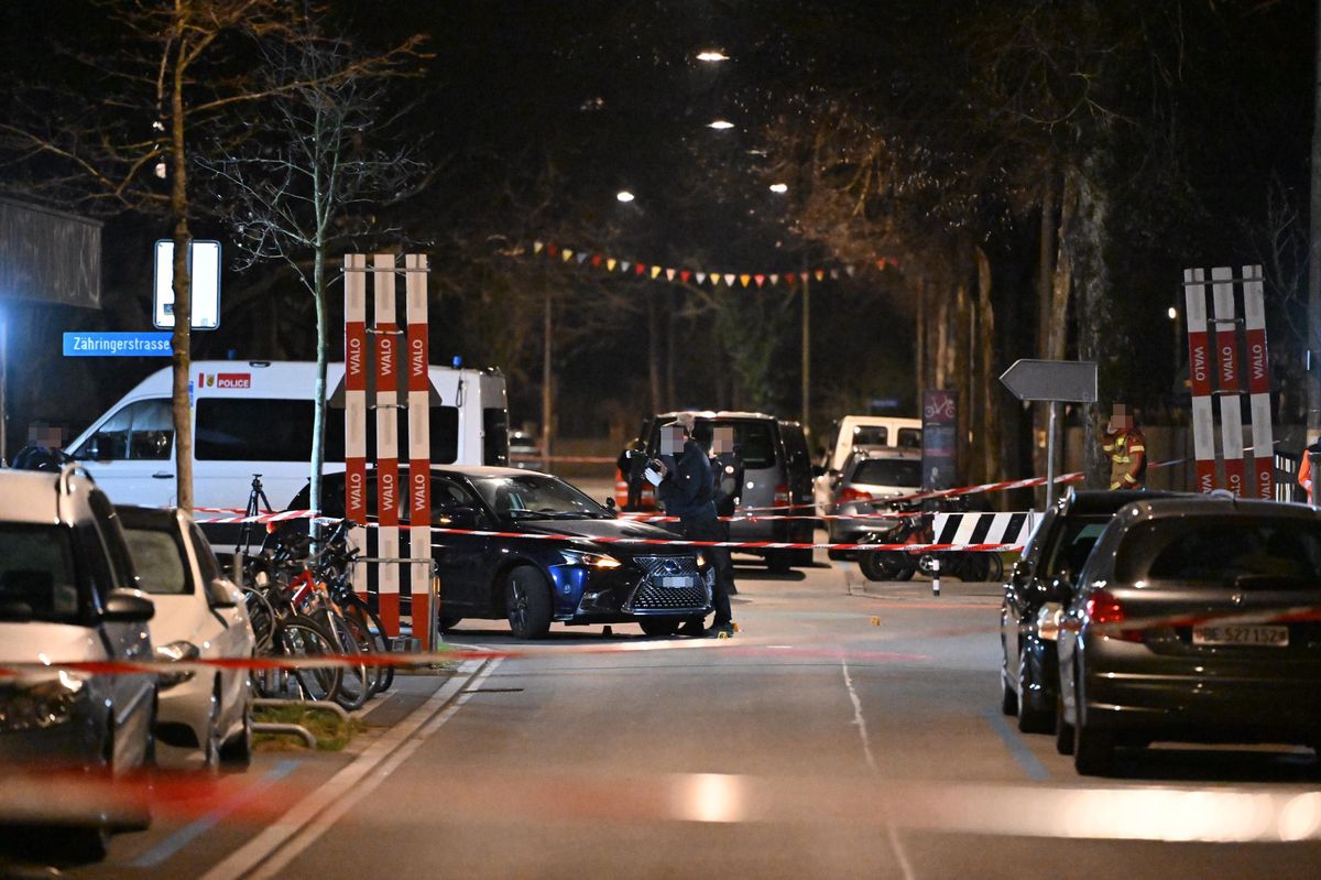 Nachtszene einer abgesperrten Strasse mit Polizeifahrzeugen und Absperrband.