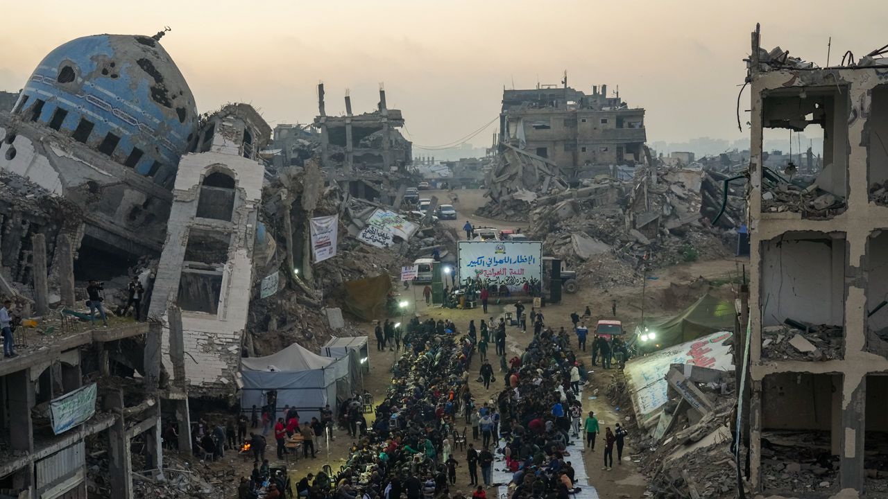 Surrounded by destroyed homes and buildings, Palestinians gather for iftar, the fast-breaking meal during Ramadan in Beit Lahia, northern Gaza Strip, Saturday, March 15, 2025. (AP Photo/Jehad Alshrafi)