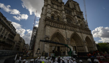 A large stone cathedral against a blue sky with clouds.