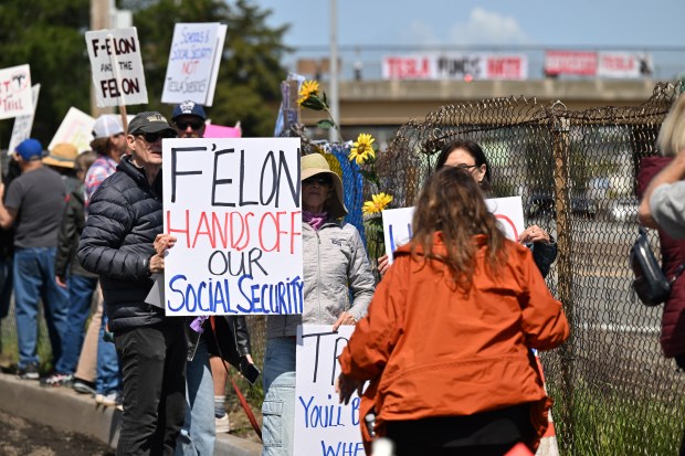 Demonstrators gather outside a Tesla dealership to protest Tesla CEO...