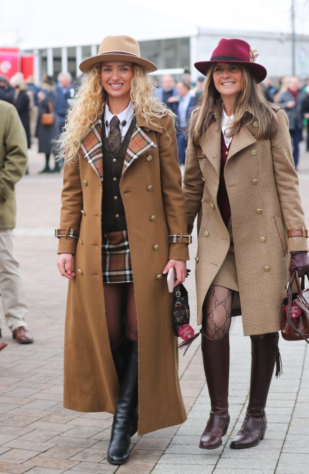 Two women in stylish outfits at a horse racing festival.