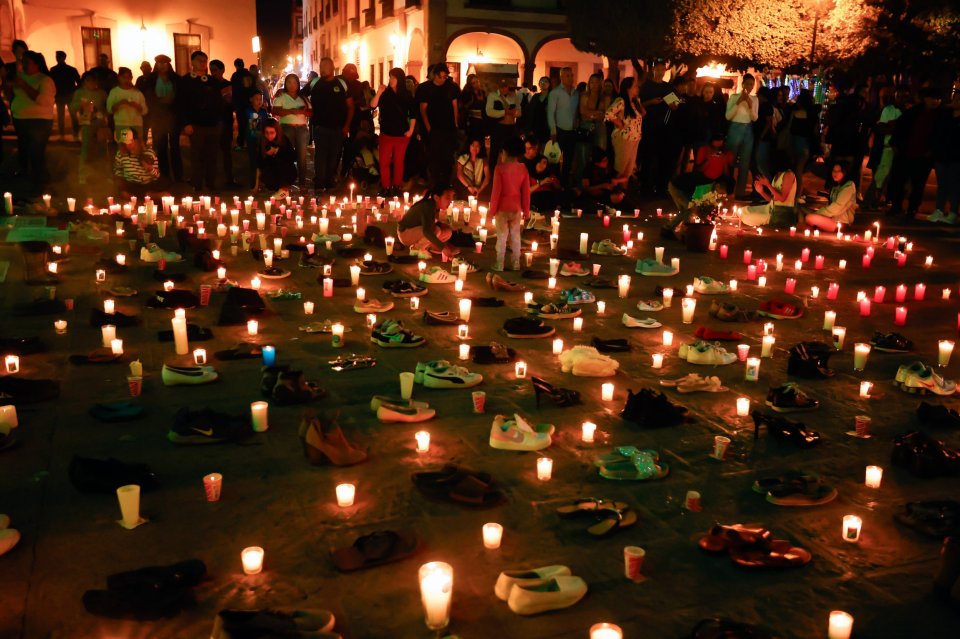Shoes and candles at a vigil.