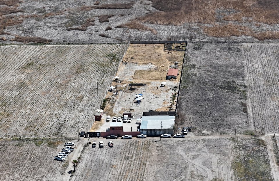 Aerial view of a crime scene in Mexico, showing vehicles and personnel from law enforcement agencies at a ranch where human crematoriums were discovered.