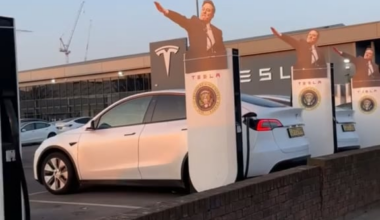 A heiling Elon Musk, with the US Presidential Seal attached to chargers at the Tesla Centre in Tottenham