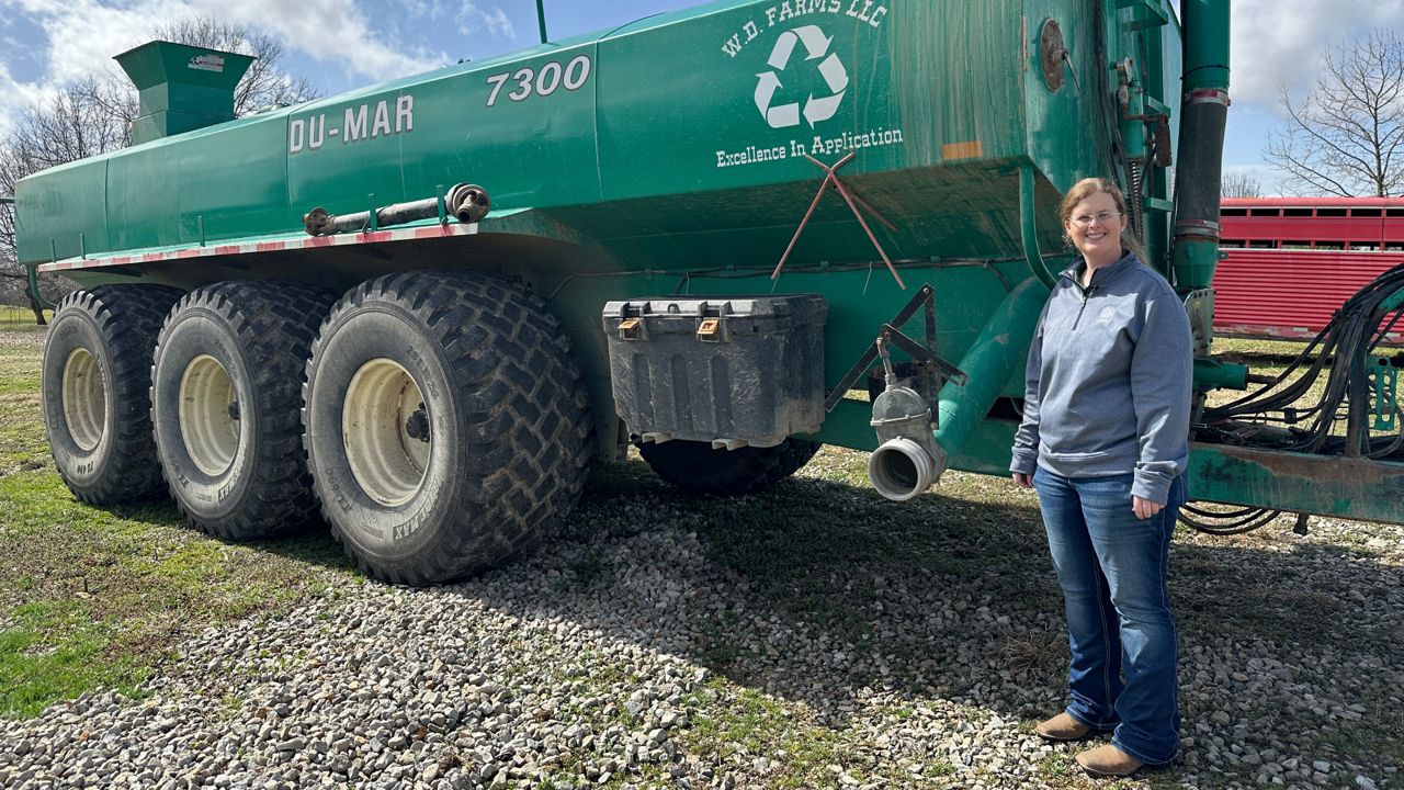 Megan Dresbach, the vice president of W.D. Farms LLC, standing next to her equipment manufactured in Canada.