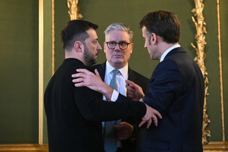 (L-R) Ukraine's President Volodymyr Zelensky, Britain's Prime Minister Keir Starmer and France's President Emmanuel Macron embrace after holding a meeting during a summit at Lancaster House in central London on March 2, 2025. European leaders descend upon London today for talks to "drive forward" action on Ukraine, according to the office of UK Prime Minister Keir Starmer. The summit caps off a week of intense diplomacy for host Starmer, who met with President Donald Trump on Thursday in an effort to draw together the European and US approaches to the Ukraine conflict. (Photo by JUSTIN TALLIS / POOL / AFP) (Photo by JUSTIN TALLIS/POOL/AFP via Getty Images)