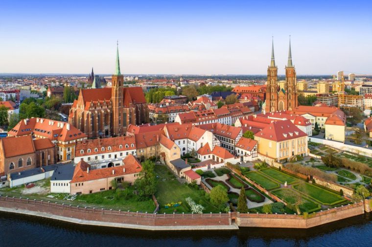 Poland. Wroclaw. Ostrow Tumski district with Gothic cathedral of St. John the Baptist, Collegiate Church of the Holy Cross and St. Bartholomew and Odra (Oder) River. Aerial view in sunset light