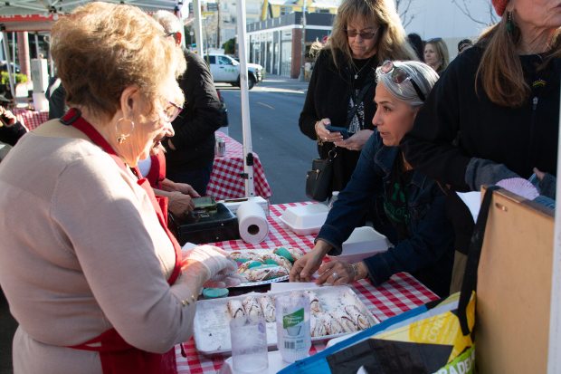 A woman buys a homemade cannoli at the Gaelic and...