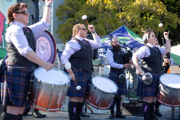 Members of the City of Angels Pipe Band perform during...