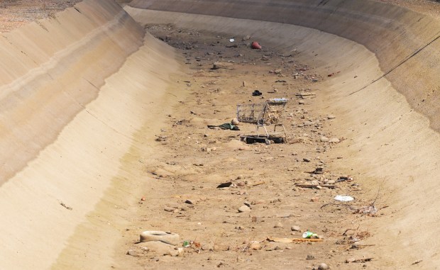 Trash and debris line a dry canal running through Pueblo on March 4, 2025. Surrounding areas have high concentrations of cadmium and other pollutants in surface soils, raising concerns about potential health risks from contaminated water and food supplies. (Photo by RJ Sangosti/The Denver Post)