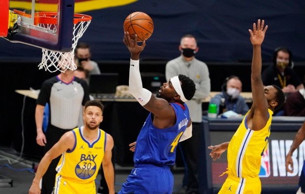 Denver Nuggets forward Paul Millsap, center, drives to the rim...