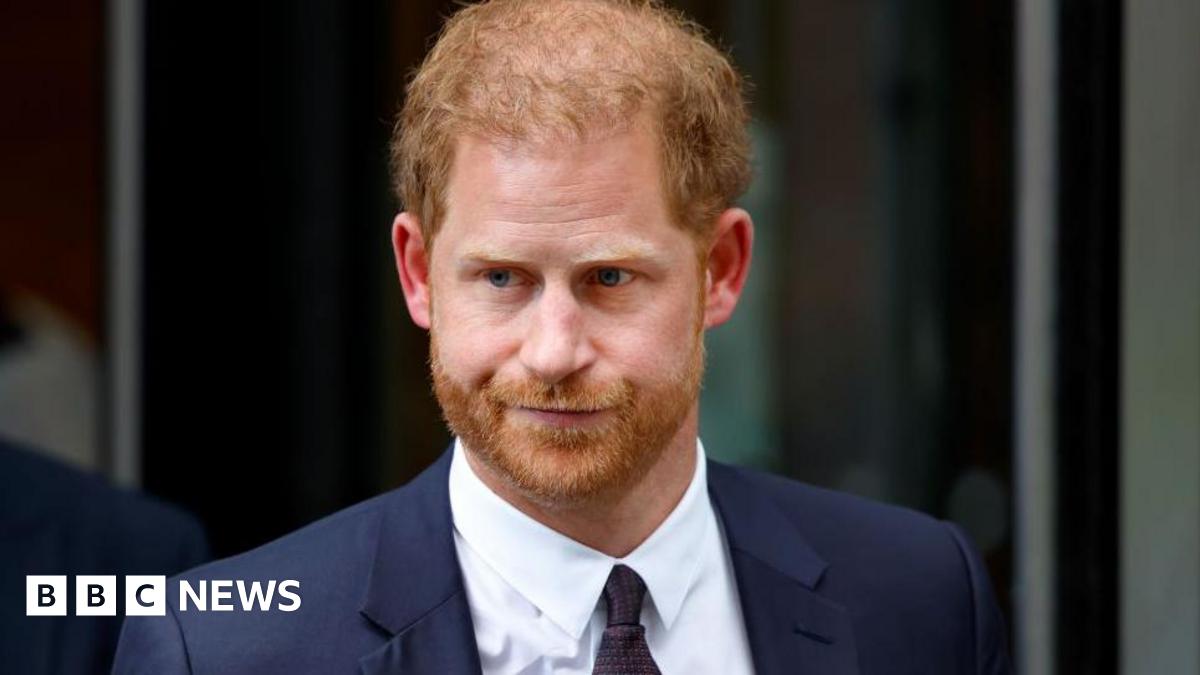 Prince Harry, Duke of Sussex, pictured in a dark suit against a black backdrop
